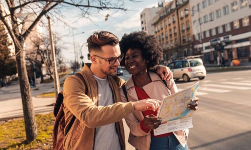 a man and woman looking at a map in the city