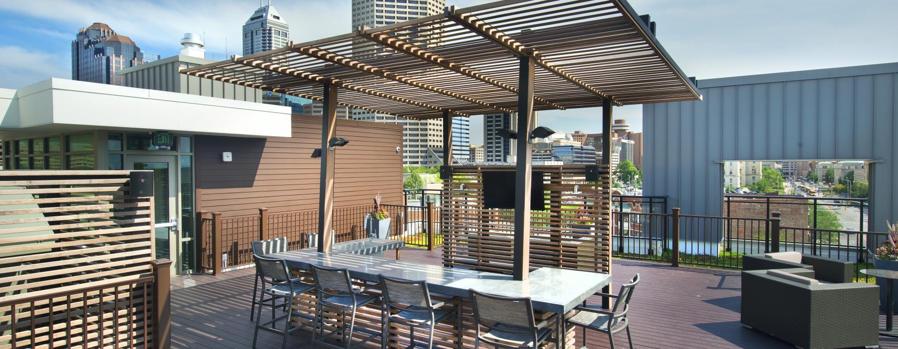 a patio with tables and chairs on it with buildings in the background
